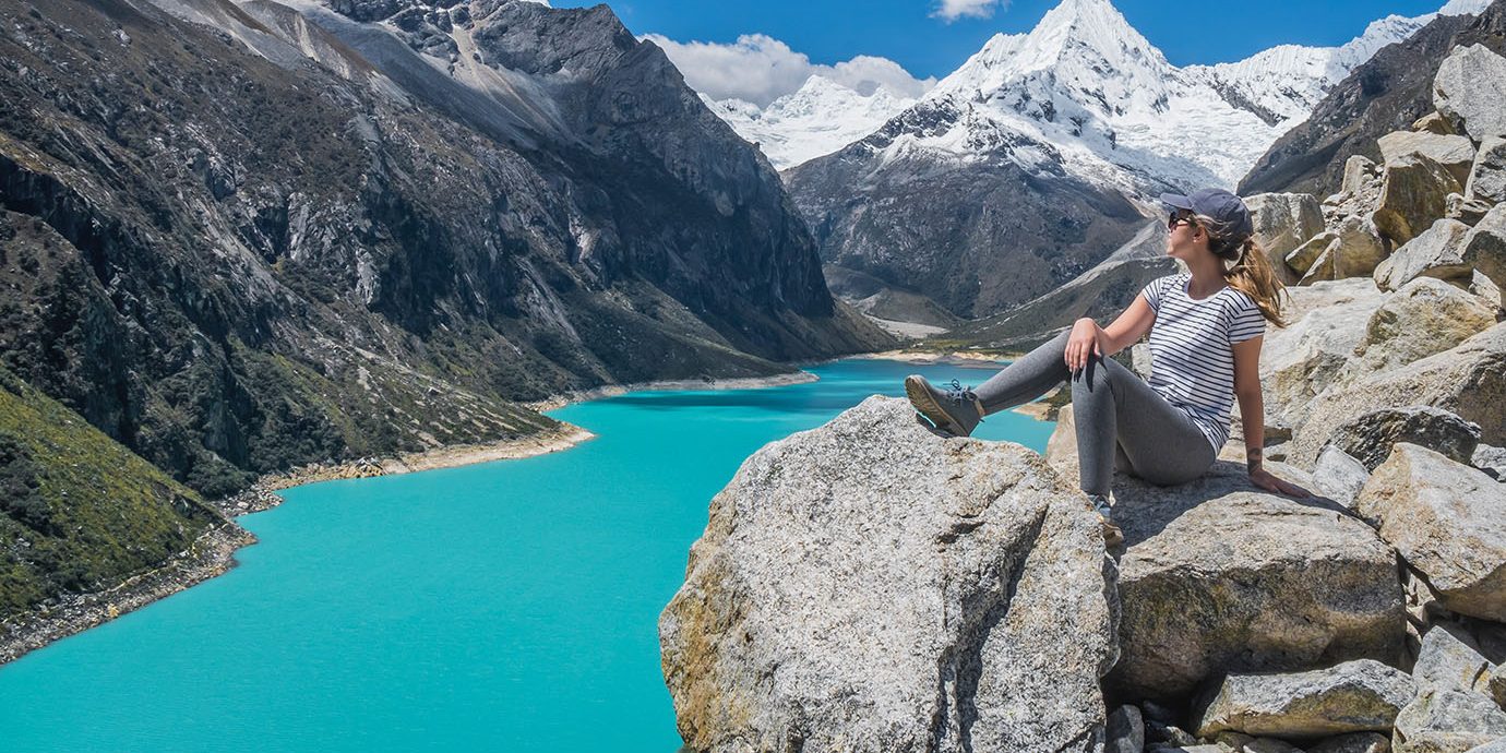Woman sitting on rocks wearing ideal travel outfit