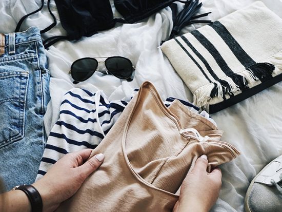 Woman Folding clothing and packing a suitcase.