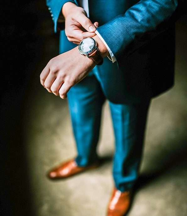 Man in a Blue Suit Fastening his Watch