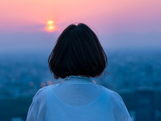 Woman watching the sunset in Tokyo Japan.
