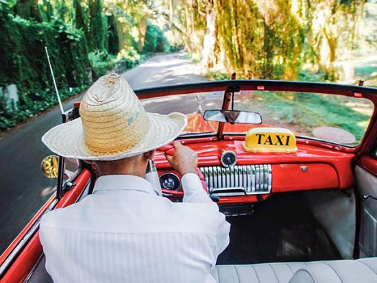 Man Driving a Taxi in Cuba.