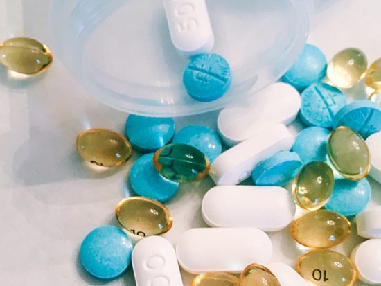 Pills split out from a bottle on a table.