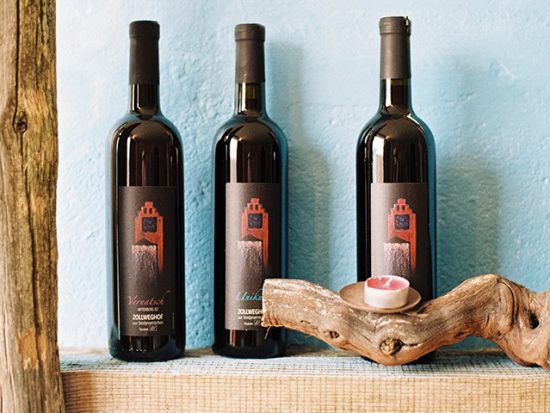 Three wine bottles on a shelf.