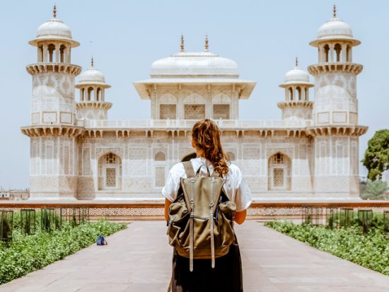 Woman standing in front of an ornate building in Agra.