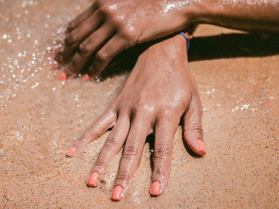 Woman's hands in the sand.