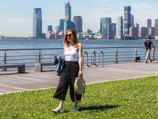 Anne Walking on the grass at a pier.