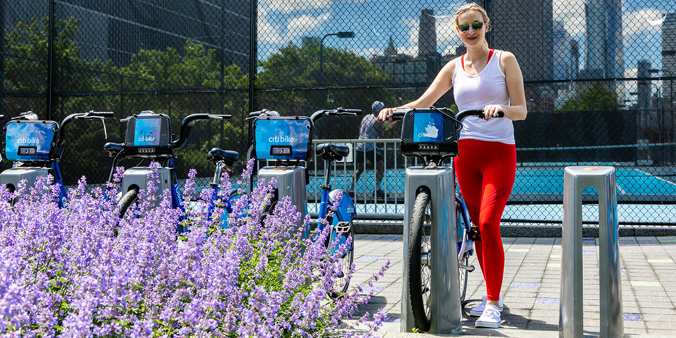 Megan getting a CitiBike while wearing Fabletics leggings.