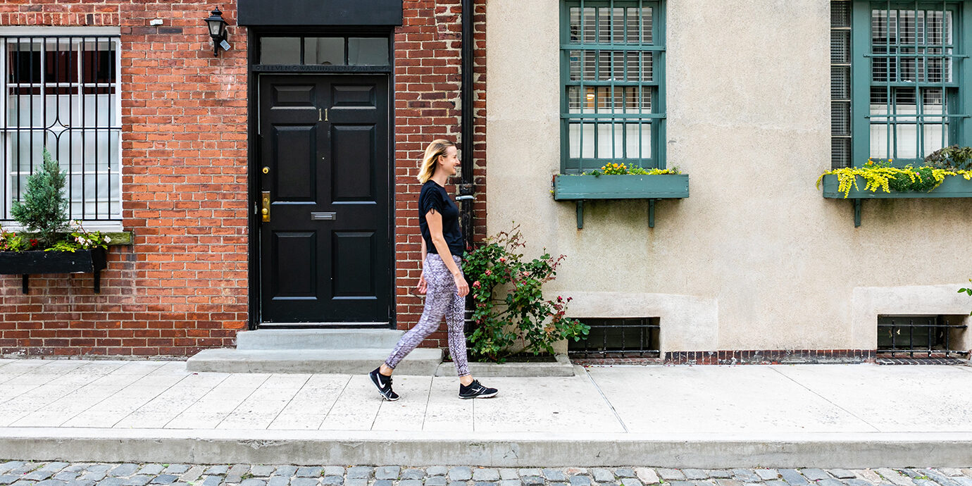 Megan walking down the street wearing Fabletics.