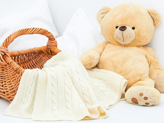 Teddy bear and blanket on a bed.