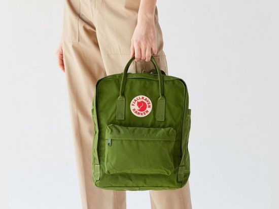 Woman holding a Fjallraven Kanken Backpack.