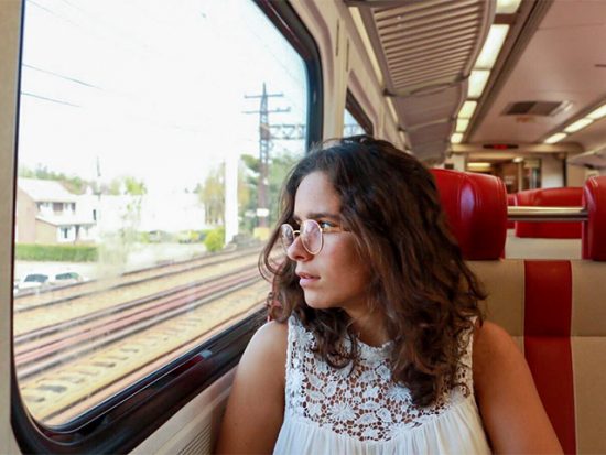 Woman sitting on a train looking out the window.