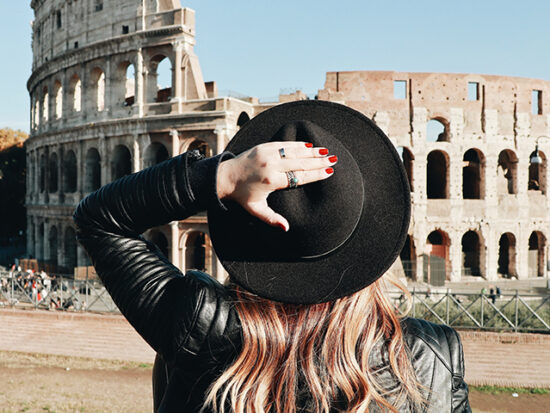 Woman Standing in front of the colisseum.