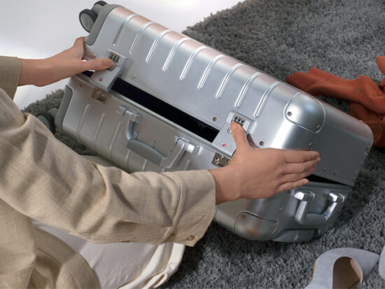 Person Closing the Away Aluminum Carry-On Suitcase.