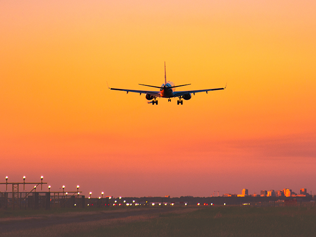 Airplane taking off at sunset.