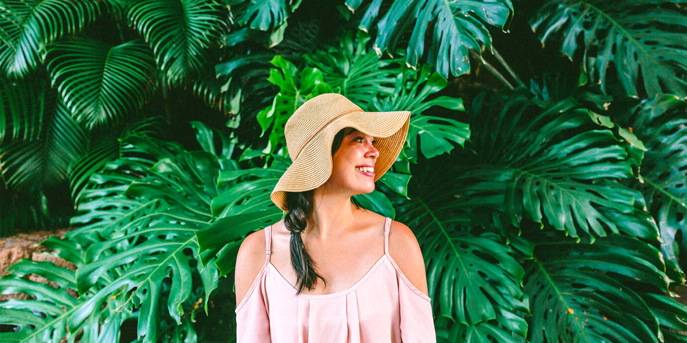 Woman standing in front of Monstera plants.