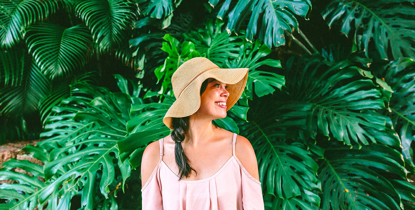 Woman standing in front of Monstera plants.